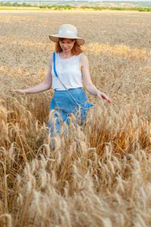 Happy woman enjoying life in field with flowers. Beauty nature, blue cloudy sky and colorful field with flowers. Outdoor lifestyle. Freedom concept. Woman in summer fieldの写真素材