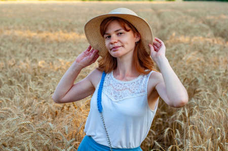 Happy woman enjoying life in field with flowers. Beauty nature, blue cloudy sky and colorful field with flowers. Outdoor lifestyle. Freedom concept. Woman in summer fieldの写真素材
