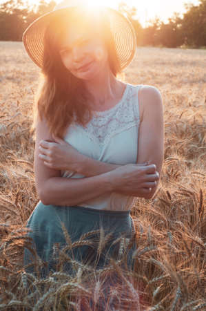 Happy woman enjoying life in field with flowers. Beauty nature, blue cloudy sky and colorful field with flowers. Outdoor lifestyle. Freedom concept. Woman in summer fieldの写真素材