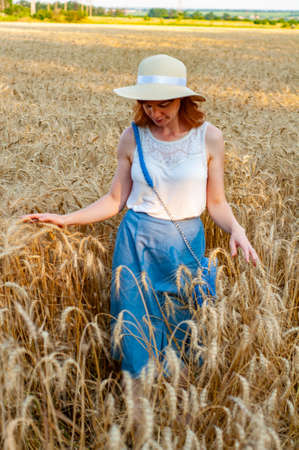 Happy woman enjoying life in field with flowers. Beauty nature, blue cloudy sky and colorful field with flowers. Outdoor lifestyle. Freedom concept. Woman in summer fieldの写真素材
