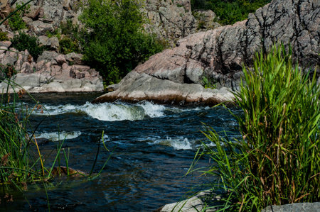 Rocky fast river. Running water, flowing with rapids, horizontal photoの写真素材