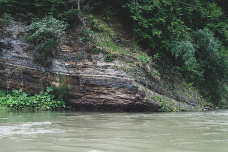 Sun glare on surface water and smooth stones at bottom stream, background. Transparent water in river with rocky bottom, fast flow. Nature outdoors close upの写真素材