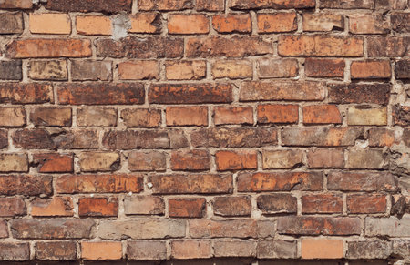 Dirty red grunge brick wall, peeling plaster, grungy texture of darkened brick.の写真素材
