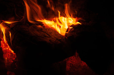 Close up of a bonfire blazing with intense heat against a dark background