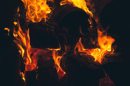 Close up of a bonfire blazing with intense heat against a dark background
