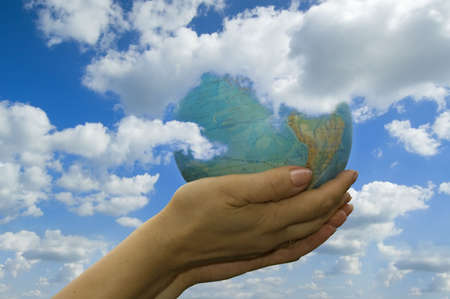 the woman keeps in hand globe on background sky.
の写真素材