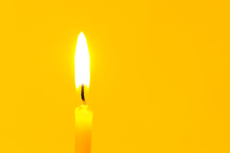 candle isolated on a yellow background の写真素材