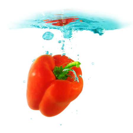 sweet pepper falling into the water isolated on a white background.                                   の写真素材