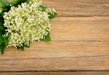 Bouquet lily of the valley on wooden table. Spring flowers on old wooden background. Top view. Copy Space for your text.の写真素材