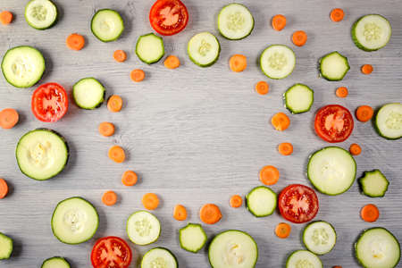 Frame natural vegetables - carrots, zucchini, tomato, cucumber. Top view healthy foods. Copy spaceの写真素材