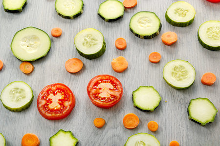 Background of healthy products on a wooden table. Top view of vegetables - zucchini, tomatoes,...