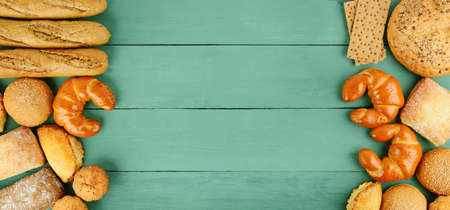 Assortment of bread on green wooden background. Top view. Copy space.の写真素材