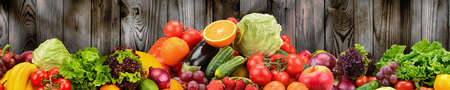 Fruits and vegetables on background of wooden wall. Healthy vegetarian food. Copy spaceの写真素材