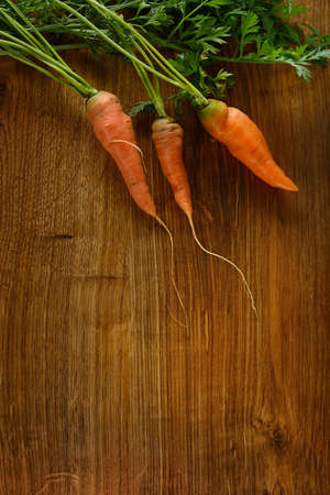Ripe carrots on dark wooden background.の写真素材