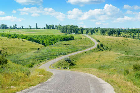 Winding road among fields in picturesque countryside.の写真素材