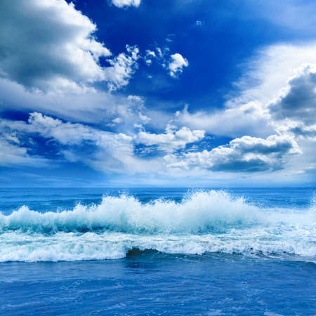 Bright ocean landscape in blue tones. Sea waves and beautiful sky with white clouds.の写真素材
