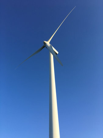 detail of sustainable energy wind turbine, with light blue background, vertical image