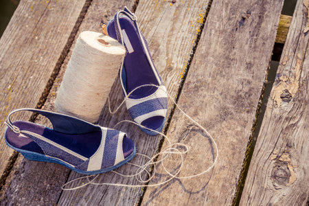 denim blue sandals lie on wooden clutch at the lakeの写真素材