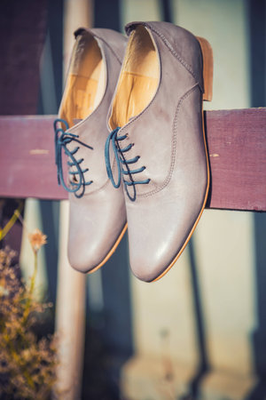 Women's shoes hanging from a wooden boardの写真素材