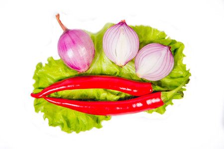 onions and chili peppers on a lettuce leafの写真素材
