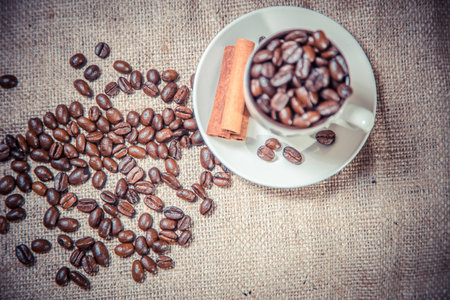 cup of coffee beans on sackclothの写真素材