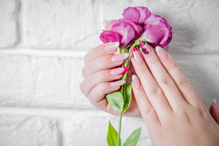 Stylish manicure on a background of flowersの写真素材