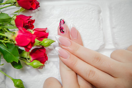 Stylish manicure on a background of flowersの写真素材
