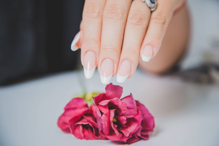 Stylish manicure on a background of flowersの写真素材