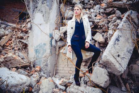 Blonde in the coat on the ruins of the houseの写真素材