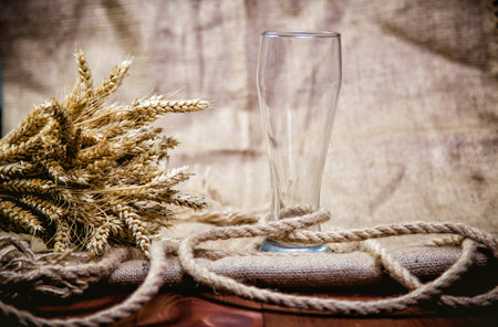 Empty beer glass with a sheaf of wheat aの写真素材