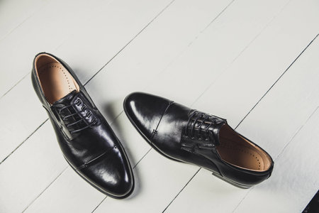 Black men's leather shoes on a white boardの写真素材