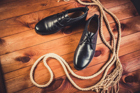 Black leather men's shoes on a wooden backgroundの写真素材