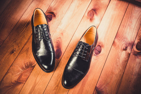 Black leather men's shoes on a wooden backgroundの写真素材