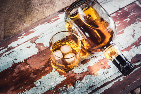 whiskey bottle and glass on a wooden vintage backgroundの写真素材