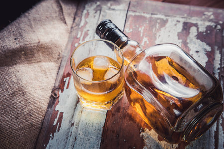 whiskey bottle and glass on a wooden vintage backgroundの写真素材
