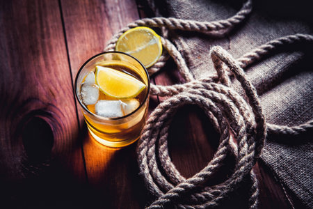 A bottle of whiskey, rum, brandy, lime on a wooden backgroundの写真素材