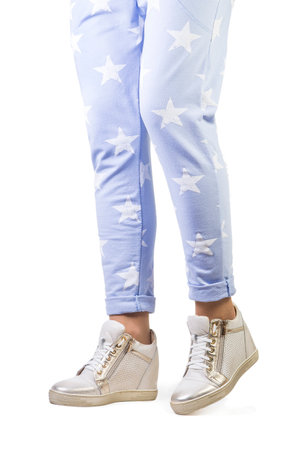 Female legs in pajamas and sneakers on a white background.の写真素材