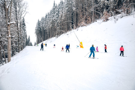Group of skiers and snowboarders on the ski slope in the mountainsの写真素材
