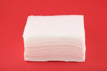 pack of paper napkins isolated on red backgroundの写真素材