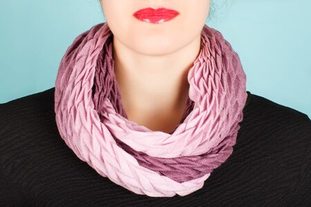 Silk scarf. Pink silk scarf around her neck isolated on blue background. Female accessory.の写真素材