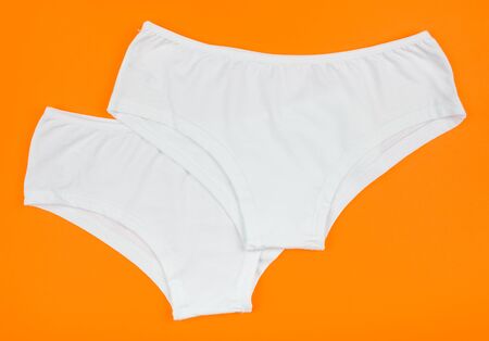 Women's cotton panties flowered isolated on orange background. White underwear.の写真素材