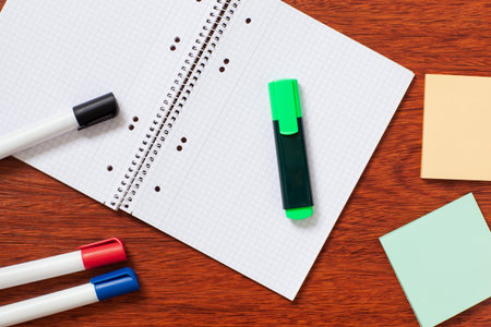 Notepad, paper, pen, pencil for study or work in the office. Isolated on wooden background.