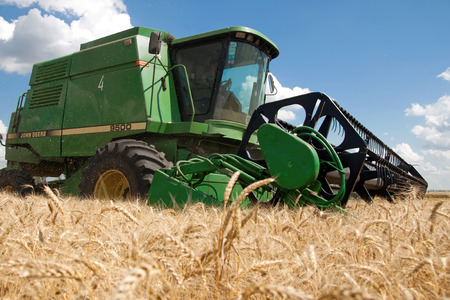 Kharkiv, Ukraine - July 12, 2011: Combine harvests wheat on a field in sunny summer day in Kharkiv Oblast, Ukraine on July 12, 2011のeditorial素材