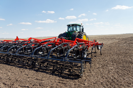Kharkiv, Ukraine - April 13, 2017: Tractor with trailed planter working in field in a sunny spring day in Kharkiv Oblast, Ukraine on April 13, 2017のeditorial素材