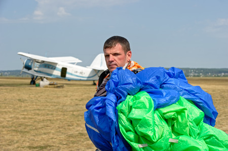 Kharkiv, Ukraine - August 26, 2017: Skydiver carries a parachute after landing at the airfield Korotych, Kharkov region, Ukraine on August 26, 2017のeditorial素材