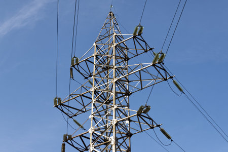 Electric pylon against the backdrop of the blue sky on a summer day