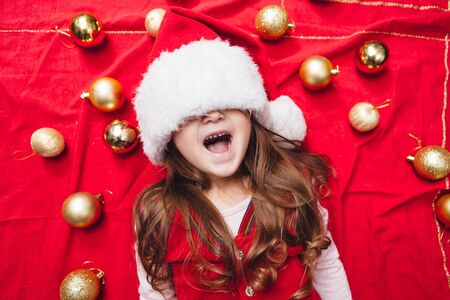 Happy girl close her eyes with christmas hat with decorationの写真素材