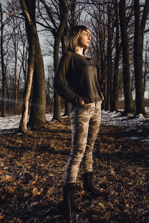 Military style girl in winter forest on backgroundの写真素材