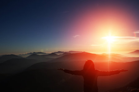 Woman on top of mountain celebrating succes. Trip concept.の写真素材