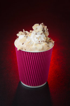 white cup and saucer with hot coffee, on red backgroundの写真素材